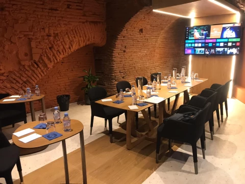 Salle de réunion pour 10 personnes, équipée et située en cave avec murs en briquette rouge, à Toulouse centre